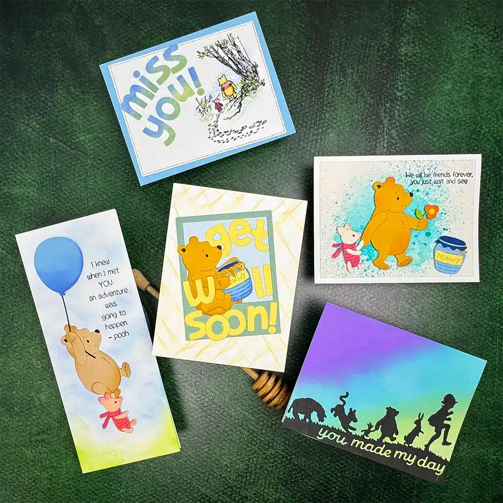 Five colorful DIY Winnie the Pooh Cards are artfully arranged on a dark green background.