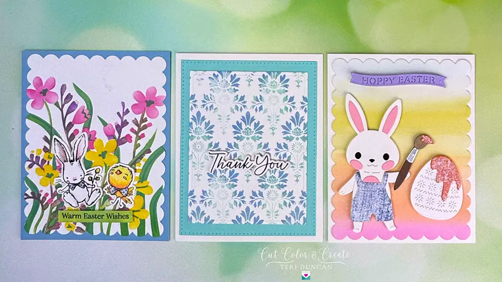 Three handmade cards from the Spellbinders Spring Release: Left, rabbits with flowers. Center, a floral pattern saying "Thank You." Right, a rabbit with an egg and paintbrush saying "Hoppy Easter.