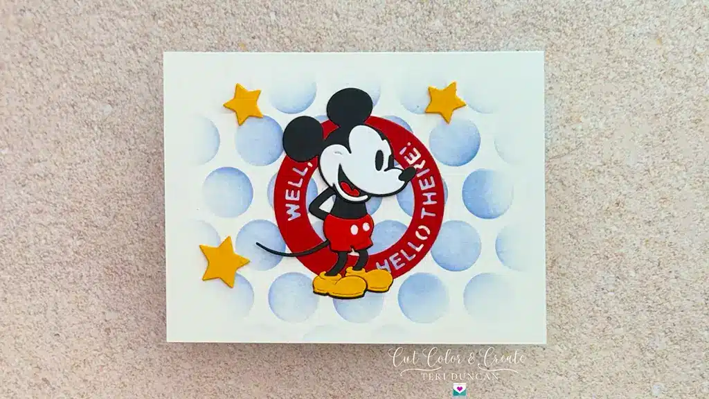 Greeting card featuring a smiling Mickey Mouse in front of a red circle with the text "WELL HELLO THERE!" and three yellow stars on a light polka dot background.