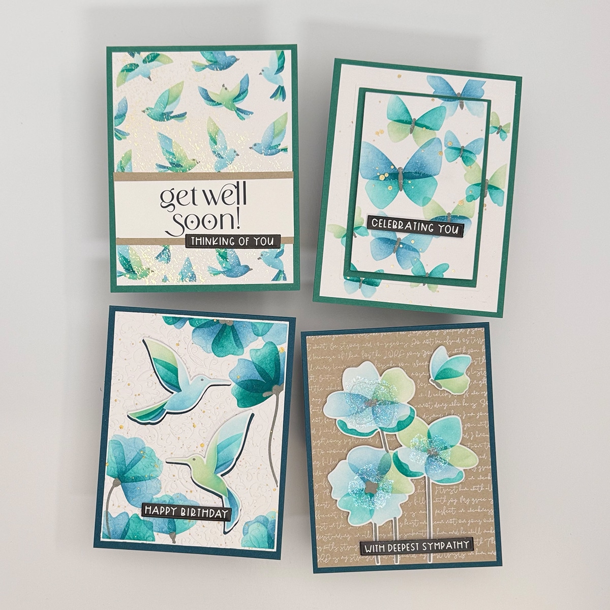 Set of 4 handmade cards with teal and blue floral and bird designs, each featuring a unique message: get well soon, celebrating you, happy birthday, and with deepest sympathy.