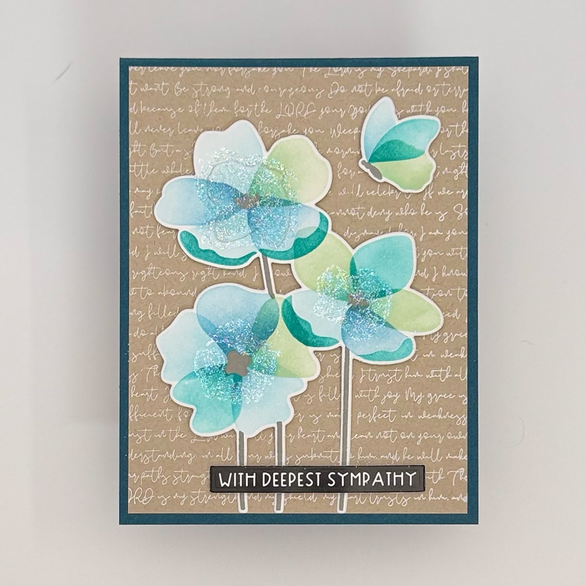 A set of 4 handmade sympathy cards by Flit & Flitter, featuring blue and green watercolor flowers with glitter accents on a tan script background and the message "With Deepest Sympathy" at the bottom.