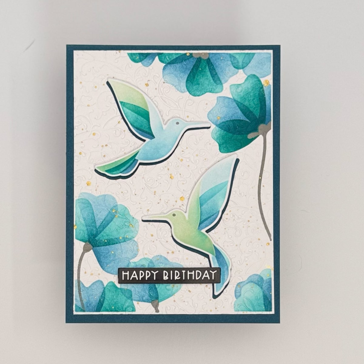 A set of 4 handmade cards featuring two illustrated hummingbirds and blue flowers, with "HAPPY BIRTHDAY" on the front from the charming Flit & Flitter collection.