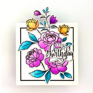 A square Off the Edge Birthday card featuring illustrated pink and yellow flowers, blue leaves, and "Happy Birthday" in decorative script.