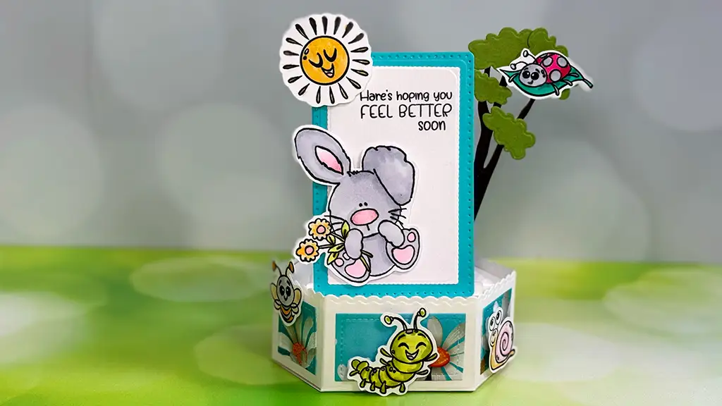 A handmade pop-up get well card features a cartoon bunny holding flowers, cheerful insects, and the message "Here's hoping you feel better soon"—the perfect get well card to brighten anyone’s day.