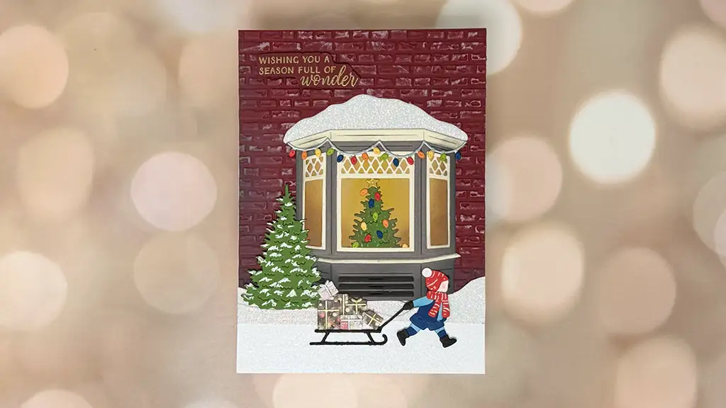 One of 4 Lovely Holiday Greeting cards showing a child pulling a sled with gifts past a decorated window, snowy ground, evergreen tree, and a brick wall with the text "Wishing you a season full of wonder.