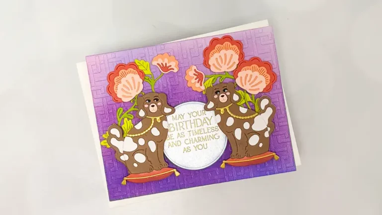 A cardmaking delight featuring two cartoon brown dogs holding pink flowers on a purple background. The card reads: "May your birthday be as timeless and charming as you." A touch of Regal Reflections for a truly special wish.