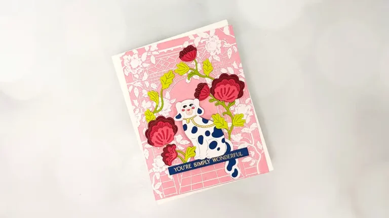 A greeting card with a pink floral background, featuring a blue and white cow illustration and the text "YOU'RE SIMPLY WONDERFUL"—a charming choice for your next cardmaking project or to add to your Regal Reflections collection.